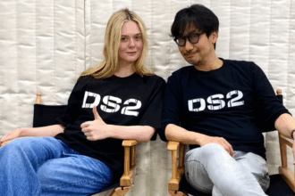 Elle Fanning e Hideo Kojima seduti su due sedie con magliette DS2 durante la promozione di Death Stranding 2
